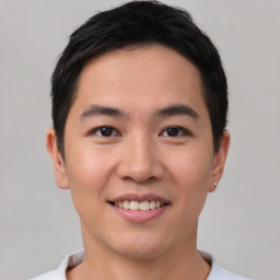 Joyful asian young-adult male with short  brown hair and brown eyes