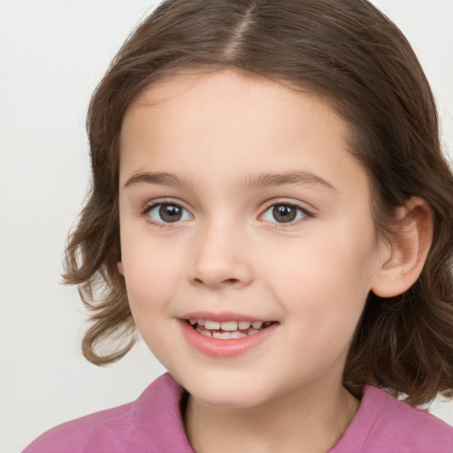 Joyful white child female with medium  brown hair and brown eyes