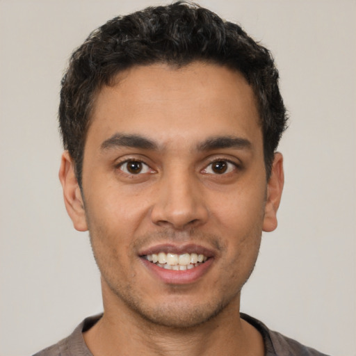 Joyful latino young-adult male with short  brown hair and brown eyes