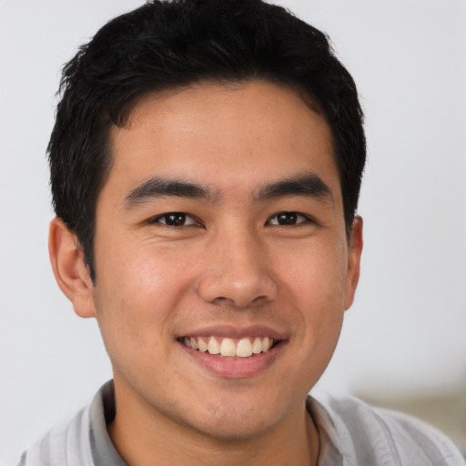 Joyful asian young-adult male with short  brown hair and brown eyes