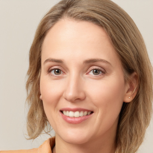 Joyful white young-adult female with long  brown hair and green eyes