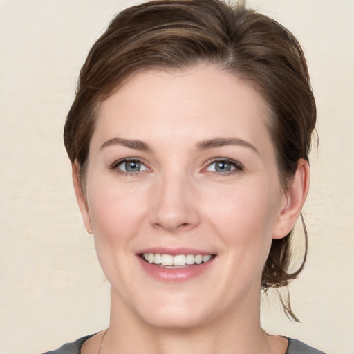 Joyful white young-adult female with medium  brown hair and grey eyes