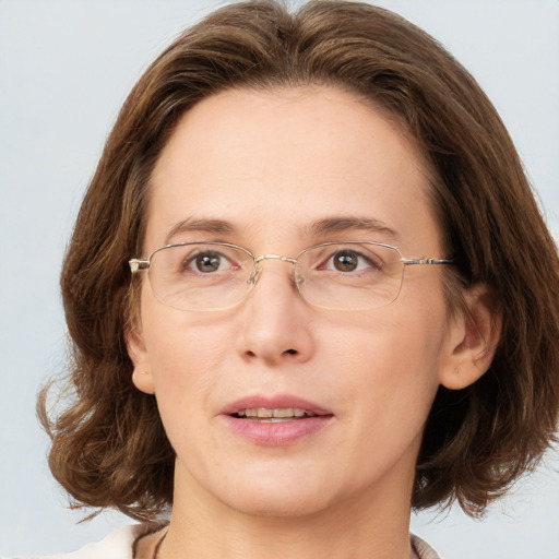 Joyful white adult female with medium  brown hair and grey eyes