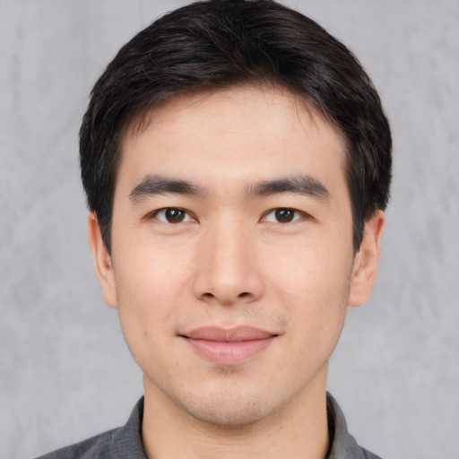 Joyful asian young-adult male with short  black hair and brown eyes