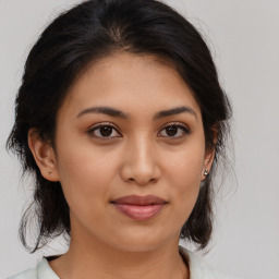 Joyful latino young-adult female with medium  brown hair and brown eyes