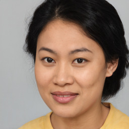 Joyful asian young-adult female with medium  brown hair and brown eyes