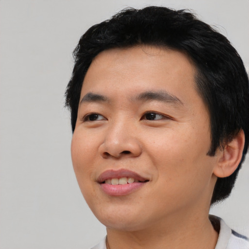 Joyful asian young-adult male with short  black hair and brown eyes