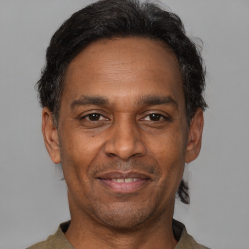 Joyful latino adult male with short  brown hair and brown eyes