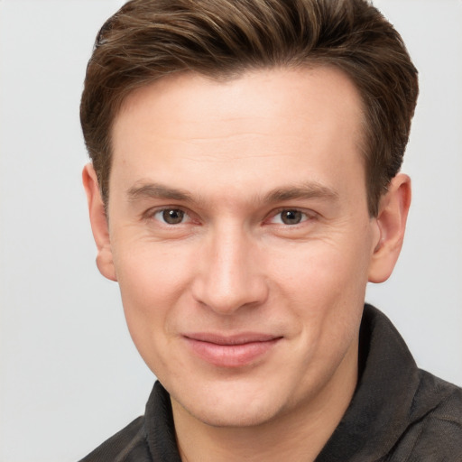 Joyful white young-adult male with short  brown hair and grey eyes