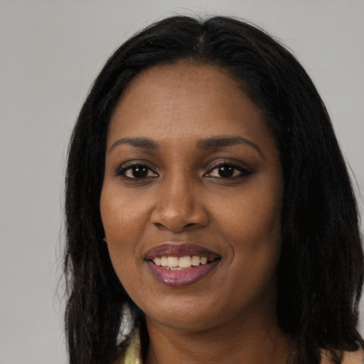 Joyful black young-adult female with long  black hair and brown eyes