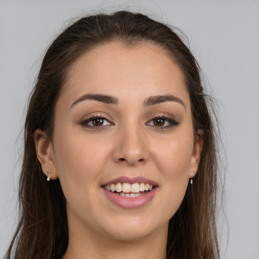 Joyful white young-adult female with long  brown hair and brown eyes