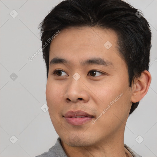 Joyful asian young-adult male with short  brown hair and brown eyes