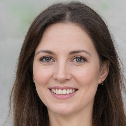 Joyful white adult female with long  brown hair and brown eyes