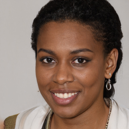 Joyful black young-adult female with short  brown hair and brown eyes
