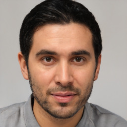 Joyful white young-adult male with short  black hair and brown eyes