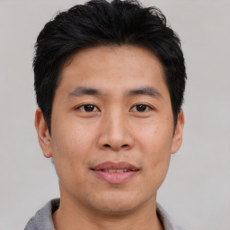 Joyful asian young-adult male with short  brown hair and brown eyes