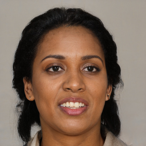 Joyful black adult female with long  black hair and brown eyes