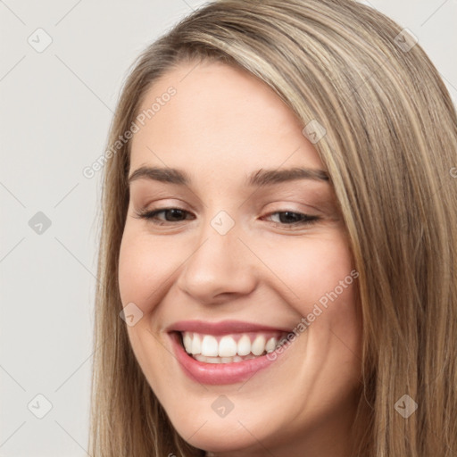 Joyful white young-adult female with long  brown hair and brown eyes