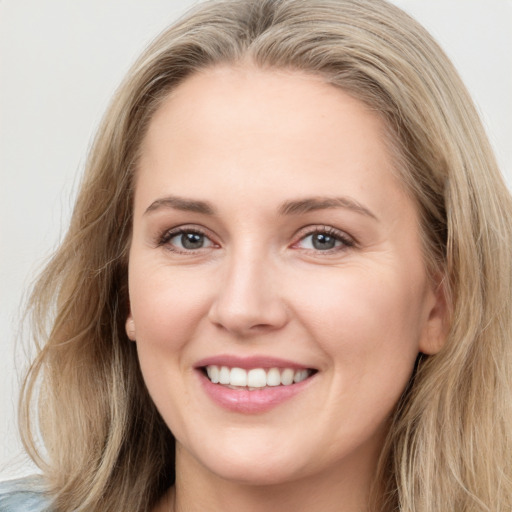 Joyful white young-adult female with long  brown hair and blue eyes