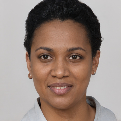 Joyful black young-adult female with short  black hair and brown eyes