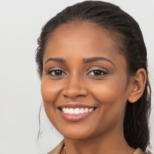 Joyful black young-adult female with long  brown hair and brown eyes