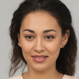 Joyful latino adult female with medium  brown hair and brown eyes