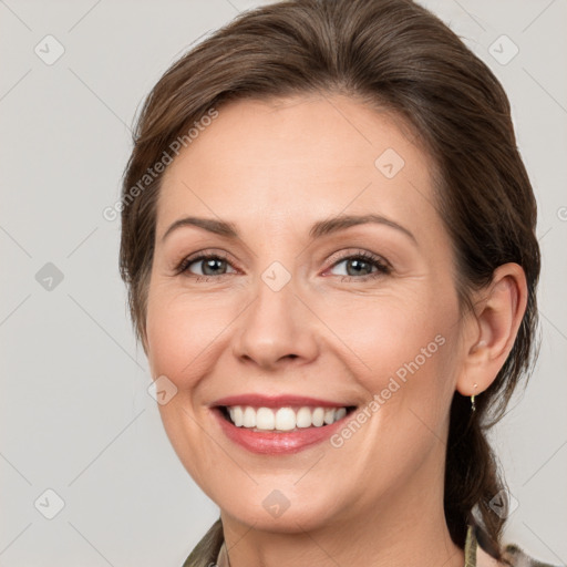 Joyful white adult female with medium  brown hair and grey eyes