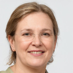 Joyful white adult female with medium  brown hair and grey eyes