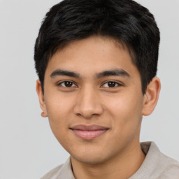 Joyful latino young-adult male with short  brown hair and brown eyes