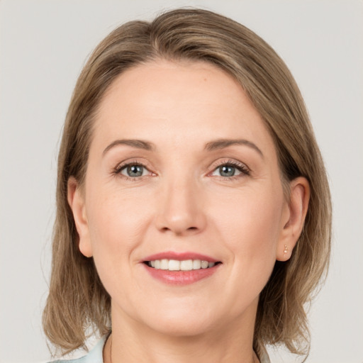 Joyful white adult female with medium  brown hair and grey eyes