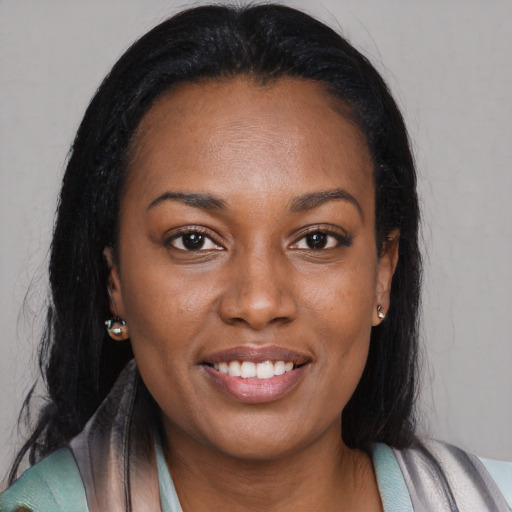 Joyful black young-adult female with long  brown hair and brown eyes