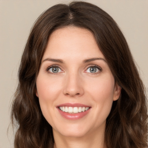 Joyful white young-adult female with long  brown hair and green eyes