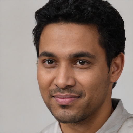 Joyful black young-adult male with short  black hair and brown eyes