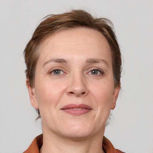 Joyful white adult female with medium  brown hair and grey eyes