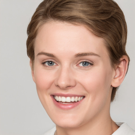 Joyful white young-adult female with short  brown hair and grey eyes