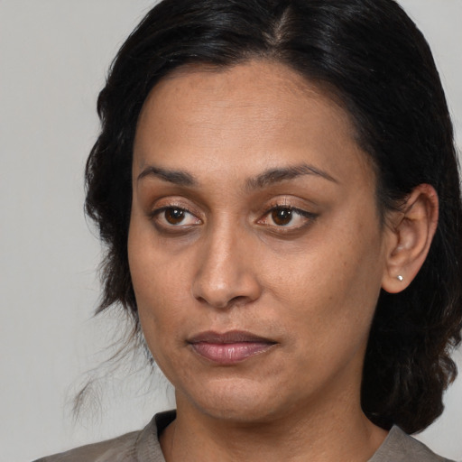 Joyful latino adult female with medium  brown hair and brown eyes