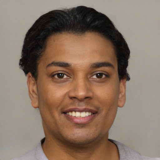 Joyful latino young-adult male with short  black hair and brown eyes