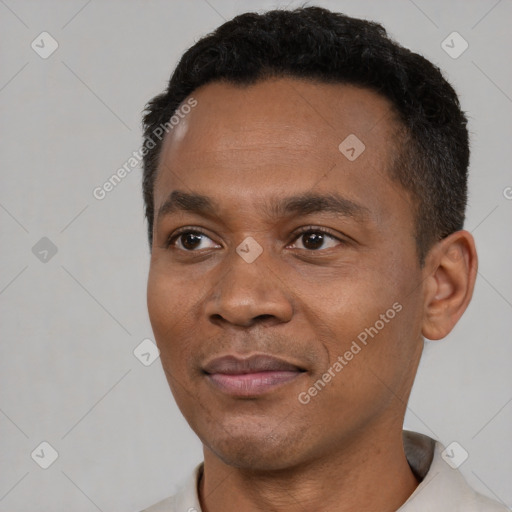 Joyful black young-adult male with short  black hair and brown eyes