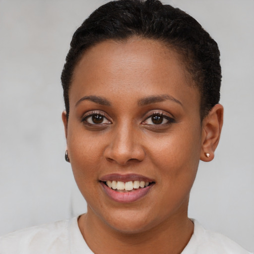 Joyful black young-adult female with short  brown hair and brown eyes