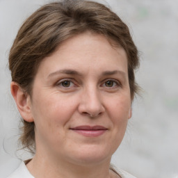 Joyful white adult female with medium  brown hair and grey eyes