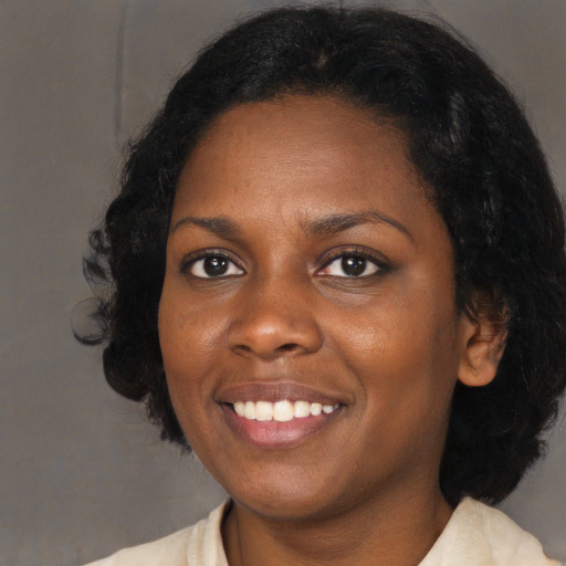 Joyful black young-adult female with medium  black hair and brown eyes