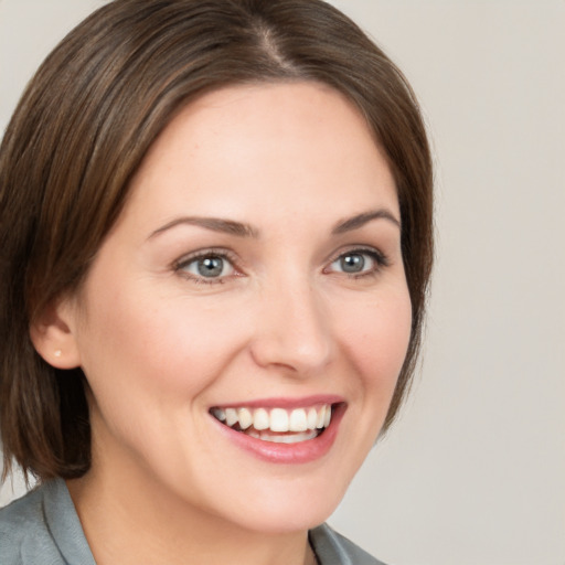 Joyful white young-adult female with medium  brown hair and grey eyes