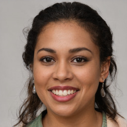 Joyful latino young-adult female with long  brown hair and brown eyes