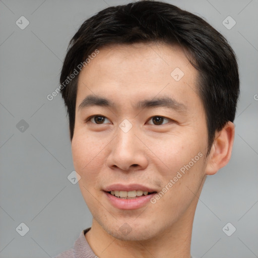 Joyful asian young-adult male with short  brown hair and brown eyes