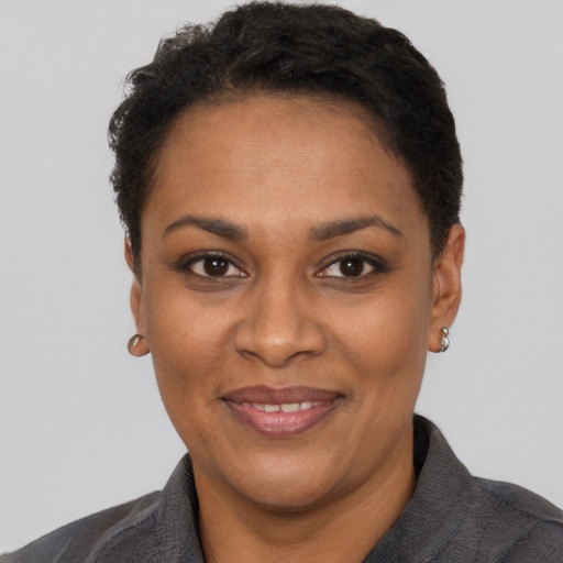 Joyful black adult female with short  black hair and brown eyes