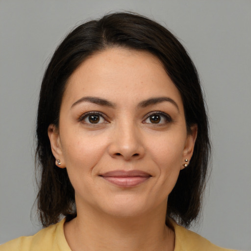 Joyful latino young-adult female with medium  brown hair and brown eyes