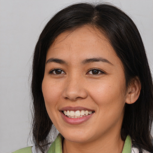 Joyful latino young-adult female with medium  brown hair and brown eyes