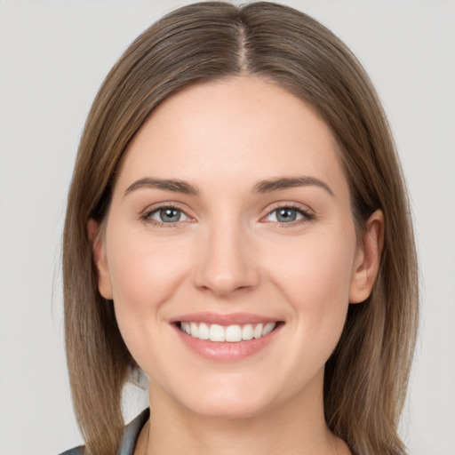 Joyful white young-adult female with medium  brown hair and grey eyes