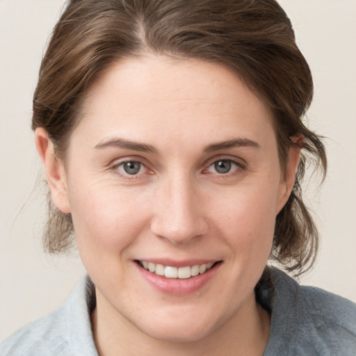 Joyful white young-adult female with medium  brown hair and grey eyes