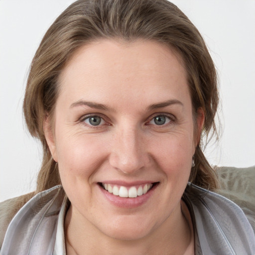 Joyful white young-adult female with medium  brown hair and grey eyes